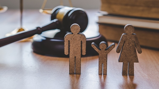 gavel and wooden family figures on desk